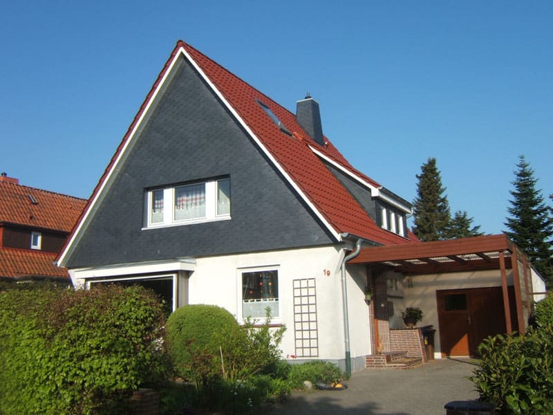Einfamilienhaus mit rotem Dach, verschiefertem Giebel und Gaube