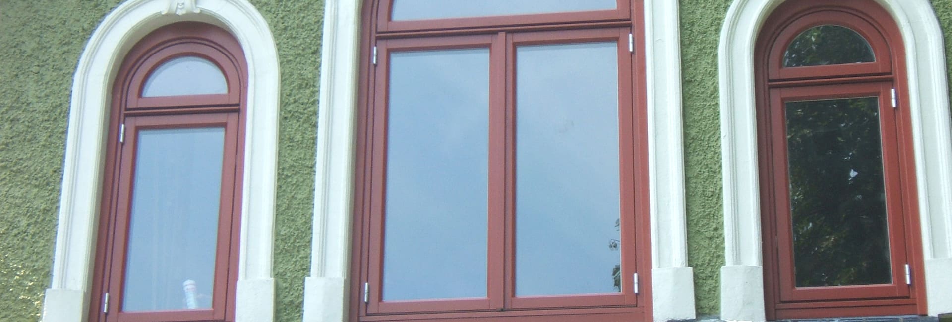 Holzfenster mit Rundbogen in einer Altbaufassade